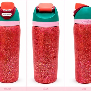 May include: A cylindrical Owala water bottle with a vibrant red glitter finish. The lid features a teal top, a coral-colored push button, and a pink collar. The push button includes white text reading Push Button and Lift to Unlock.