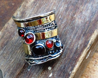 Vintage side: a solid ajustable silver and gold ring with 4 superb natural garnet cabochons ....