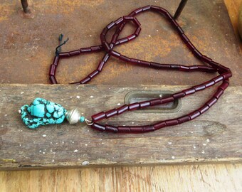 Een etnische en unisex ketting met prachtige rode glazen buizen uit Gambia en een grote turquoise nugget uit Tibet!!!: "Les Grands Chemins"