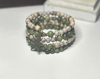 May include: A multi-strand bracelet featuring green and white beads with a silver star charm.
