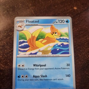 May include: A Floatzel trading card featuring the orange and yellow Sea Weasel Pokémon swimming in blue water. The card displays 120 HP, the attacks Whirlpool and Aqua Slash, and includes the text No. 0419 Sea Weasel Pokémon HT 3'7" WT 73.9 lbs.