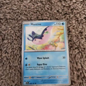 May include: A Mantine Pokémon trading card. The card features a blue background with the name "Mantine" at the top. The illustration shows a pink and blue creature. The card has attack details and a 110 HP rating.