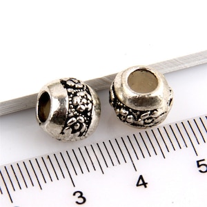 European style large hole barrel shape with flower pattern alloy beads. Pack of 2 or 4 beads. For Euro style snake chain, cord or leather