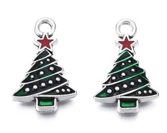 May include: Two Christmas tree charms. Each charm features a black tree with green trim, white dot accents, and a red star on top. The charms have a silver-colored loop at the top and a green rectangular base.