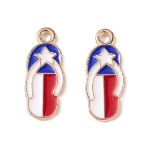 Puede incluir: Dos abalorios de metal dorado en forma de chanclas con un diseño de esmalte rojo, blanco y azul que se asemeja a la bandera de Texas.