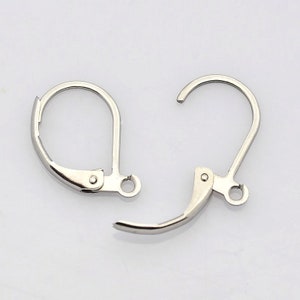 May include: Two silver earring hooks with a lever back closure. The hooks are made of metal and have a shiny finish.