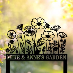 May include: Black metal garden sign with a silhouette of flowers and the text "Mike & Anne's Garden".
