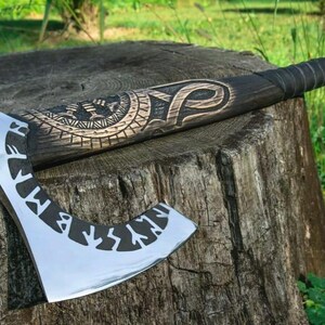 May include: A hand-crafted axe with a black wooden handle and a silver blade. The handle is decorated with intricate carvings and runes. The axe is resting on a tree stump.
