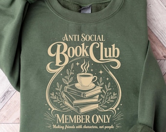 以下が含まれることがあります： ヴィンテージスタイルのフォントで「ANTI SOCIAL Book Club」と書かれた緑色のスウェットシャツ。デザインには、本の上にコーヒーカップがあり、「MEMBER ONLY」と「Making friends with characters, not people」という言葉が下にあります。