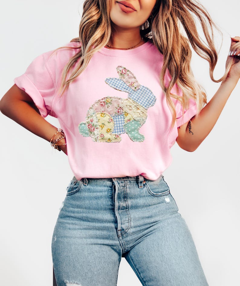 以下が含まれることがあります： パッチワークのウサギのデザインが特徴の、明るいピンク色のTシャツ。 ウサギは、パステルカラーの様々な花柄とギンガムチェックの生地で作られています。 このシャツは半袖で、リラックスしたフィット感があり、普段着に最適です。