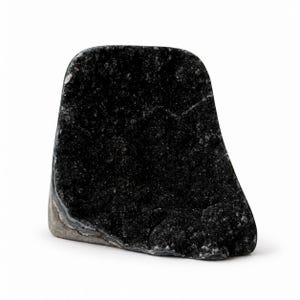 Op de afbeelding: Een zwart geode-exemplaar met een kristallijn, getextureerd binnenoppervlak en een gladde, grijs-witte buitenrand. De mineraalformatie heeft een afgeronde bovenkant en een onregelmatige, hoekige vorm met natuurlijke donkere afzettingen.