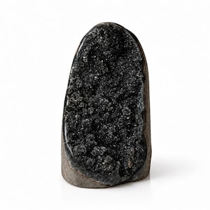 May include: A vertical, dome-shaped geode featuring a deep black, crystalline interior with a rough, textured surface. The outer edge of the stone is smooth and dark gray, contrasting with the sparkling, dark mineral cluster inside.