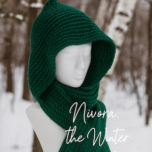 Può includere: Un cappuccio e una sciarpa lavorati a maglia verde scuro, esposti su un manichino. Il cappuccio è a punta e la sciarpa scende. Il testo sull'immagine recita "Nivora, the Winter Magic Hood". Lo sfondo è una foresta innevata.
