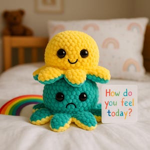 May include: A handmade yellow and teal crochet octopus toy with a happy face on top and a sad face on the bottom. The toy has large black eyes and eight tentacles. A small card reads "How do you feel today?"