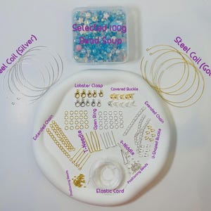 May include: A jewelry-making kit with various components. Includes a container of blue and white beads, silver and gold steel coils, clasps, open rings, extended chains, T-needles, and elastic cord. The kit is arranged on a white, oval-shaped tray.