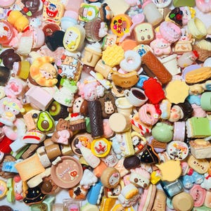 May include: A collection of miniature food charms in various shapes and colors. The charms include donuts, sushi, waffles, and other desserts. Some charms have cute faces and details.