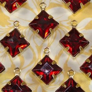 May include: Ten red square-shaped glass charms with gold metal frames and loops. The charms are perfect for adding a touch of sparkle to jewelry, crafts, and other projects.
