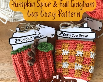 May include: Two handmade crochet cup cozies, one pumpkin-themed and the other a gingham pattern, are displayed on coffee cup-shaped cards. The text "Pumpkin Spice & Fall Gingham Cup Cozy Pattern" is visible. The image includes yarn and a crochet hook.