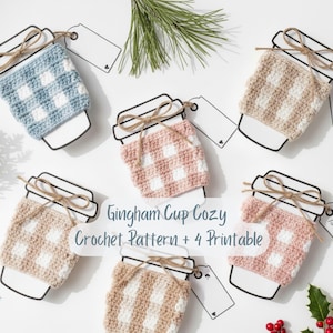 May include: An overhead shot displays six crochet cup cozies in various colors, each with a gingham pattern. The cozies are placed on coffee cup outlines with twine bows and blank tags. The text "Gingham Cup Cozy Crochet Pattern + 4 Printable" is visible.