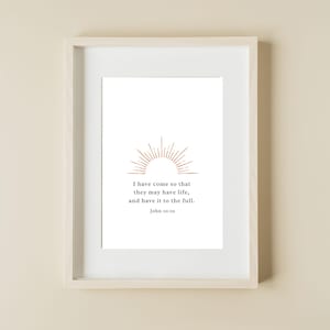 May include: A white framed print with a gold sunburst design and the text "I have come so that they may have life, and have it to the full. John 10:10"