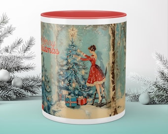 May include: A ceramic mug with a red interior and a vintage Christmas scene. The design features a woman in a red dress decorating a Christmas tree, with the words "Merry Christmas" and "Twinkle & Twist".