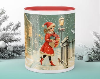 Puede incluir: Una taza de Navidad roja y blanca con una niña que lleva regalos en una escena de invierno nevada. La taza tiene un borde rojo y el texto "The Season" en el lateral.