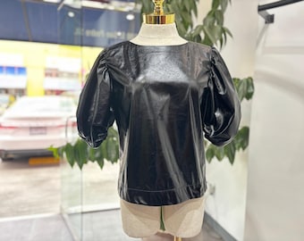Blusa negra de piel sintética con mangas abullonadas: blusa brillante y llamativa