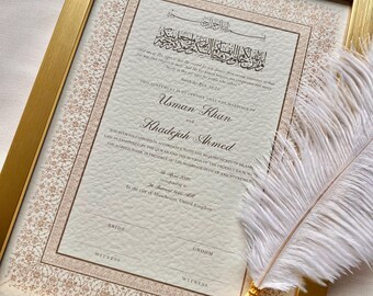 Può includere: Un certificato di matrimonio islamico incorniciato con lettere dorate ornate e motivi floreali. Il certificato recita: "Questo Accordo è per Certificare che il Matrimonio di Usman Khan e Khadejah Ahmed è stato solennemente celebrato in conformità con i requisiti della Legge Islamica come sancita dal Corano e dalla Sunnah del Profeta SAW, in presenza dell'Ufficiale di Matrimonio e dei Testimoni." Il certificato è datato 28 aprile 2023, corrispondente al 27 Shawwal 1446 Hijri, nella città di Manchester, Regno Unito.