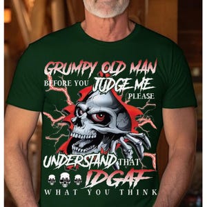 May include: Dark green t-shirt with a graphic of a skull bursting through a red tear. The text reads "Grumpy Old Man, Before You Judge Me, Please Understand That IDGAF What You Think."