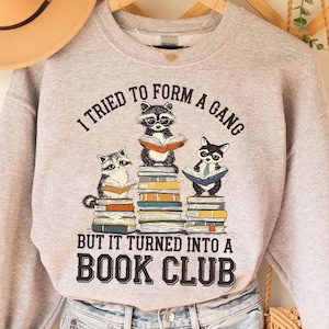 a raccoon is sitting on top of a stack of books