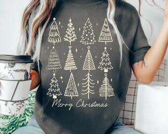 May include: A dark gray short-sleeve t-shirt featuring a grid of twelve unique white line-art Christmas tree illustrations. Below the trees, the text Merry Christmas is printed in a white cursive script font.