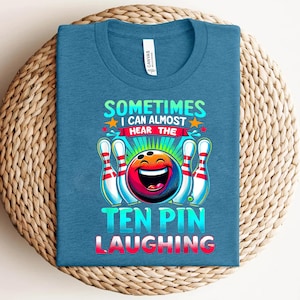 May include: A blue t-shirt with a bowling ball graphic and the text "Sometimes I can almost hear the ten pin laughing".