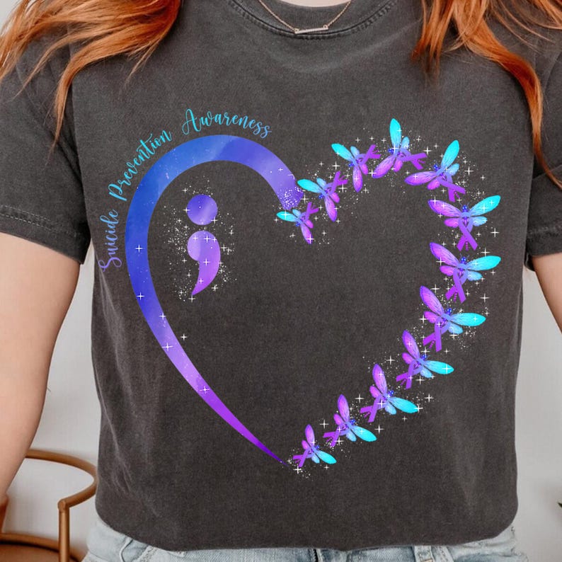 a woman wearing a t - shirt with a heart and butterflies on it