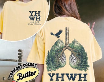 May include: A butter yellow t-shirt featuring a small front graphic with the text YHWH every breath speaks His name. The back displays a large graphic of lungs formed by tree branches and mountains, a flying eagle, and the text YHWH every breath speaks His name.