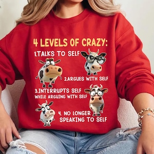 May include: A red sweatshirt with the text "4 LEVELS OF CRAZY" and illustrations of cows. The levels are: Talks to Self, Argues with Self, Interrupts Self While Arguing with Self, and No Longer Speaking to Self.