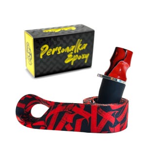 May include: A red and black patterned fabric wrap with a loop for a vape mod, a black and silver vape mod, and a red and black marbled vape tip. The box in the background says "Personalka Epoxy".