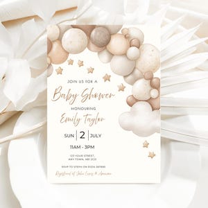 May include: Baby shower invitation in a neutral colour scheme. The design includes beige and brown balloons, stars, and clouds. The invitation features the text "Baby Shower" and details for Emily Taylor's baby shower.