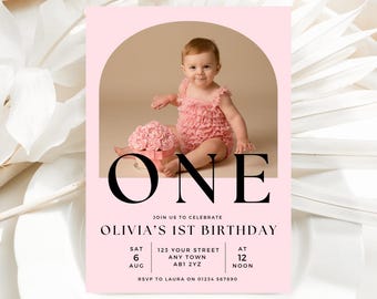 Può includere: Un invito rosa per il primo compleanno di Olivia. La carta presenta una foto di un bambino in un completo rosa con volant, una scatola rosa con fiori e la parola "ONE". L'invito include i dettagli dell'evento.
