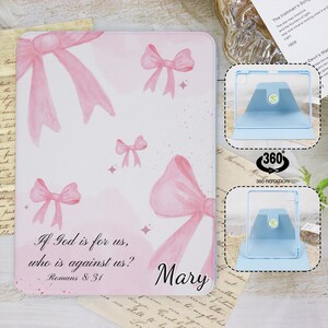 Peut inclure: Une coque d'iPad rose avec un motif aquarelle de nœuds roses et la citation "Si Dieu est pour nous, qui est contre nous ? Romains 8:31". La coque porte également le nom "Mary".