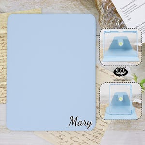 May include: Light blue iPad case with a 360 degree rotating stand. The case has the name "Mary" printed on the front.