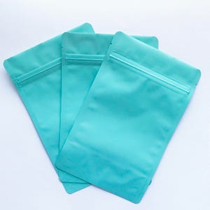 100-6x9 MATTE TURQUOISE Stand Up Pouches, Heavy Duty 5.4mil, Tear Notch, Impulse + Zipper Seal, Two Wild Hares