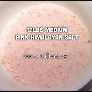 Puede incluir: Primer plano de 12 libras de sal rosa del Himalaya de grano medio. La sal está en un tazón blanco y parece estar finamente molida.