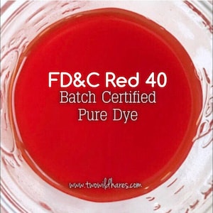 May include: A glass jar filled with a bright red liquid. The label reads "FD&C Red 40 Batch Certified Pure Dye" and "www.twowildhares.com".