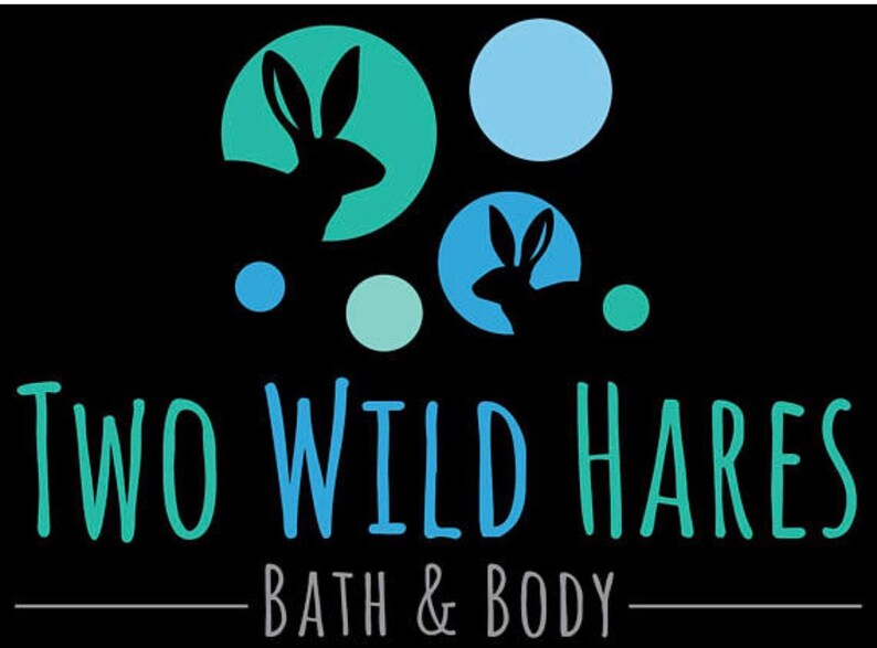 Puede incluir: Logotipo de una empresa de ba&ntilde;o y cuerpo llamada "Two Wild Hares". El logotipo presenta dos liebres estilizadas en c&iacute;rculos azules y verdes sobre un fondo negro.