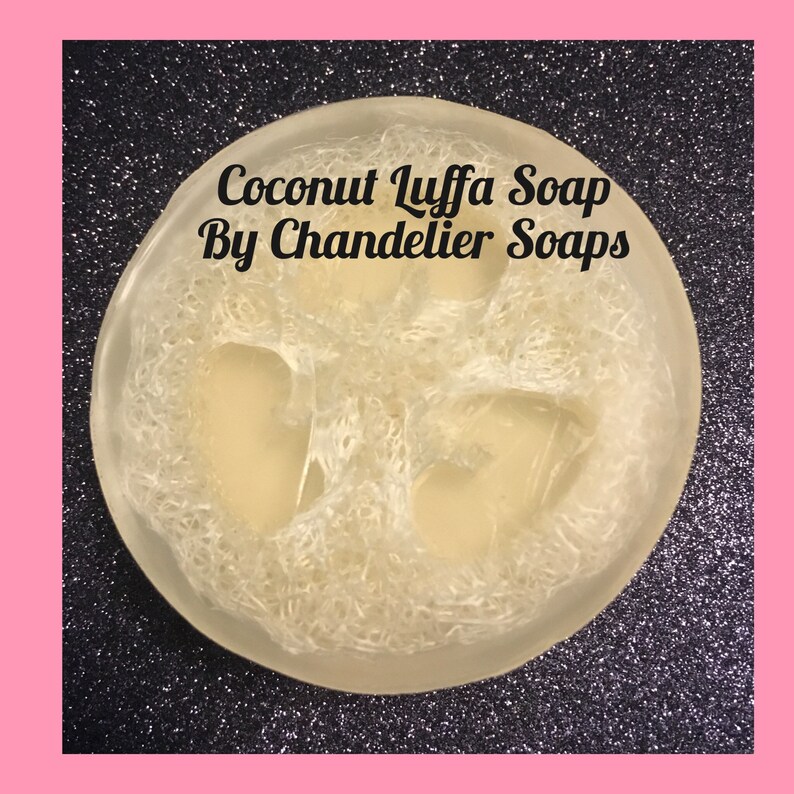 May include: A round, white, loofah soap bar with the text "Coconut Luffa Soap By Chandelier Soaps" on top.