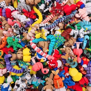 May include: A vibrant assortment of colorful, small, handmade animal figurines. The collection includes various creatures in shades of red, yellow, blue, and brown. The figurines appear to be made of a soft material, creating a playful and whimsical aesthetic.