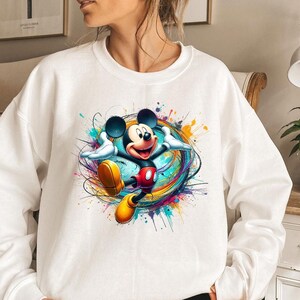 a woman wearing a sweatshirt with a mickey mouse graphic on it
