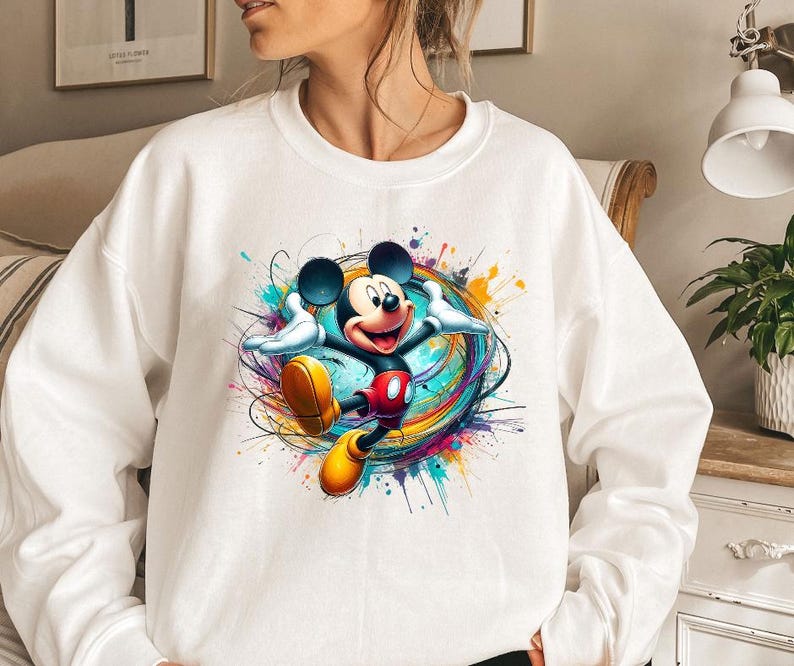 a woman wearing a sweatshirt with a mickey mouse graphic on it