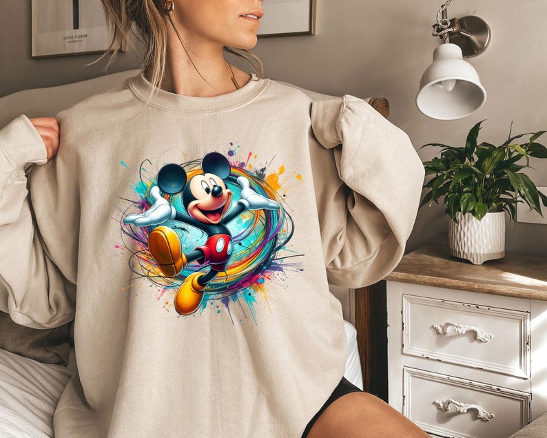a woman wearing a sweatshirt with a mickey mouse graphic on it