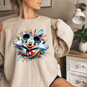 a woman wearing a sweatshirt with a mickey mouse graphic on it